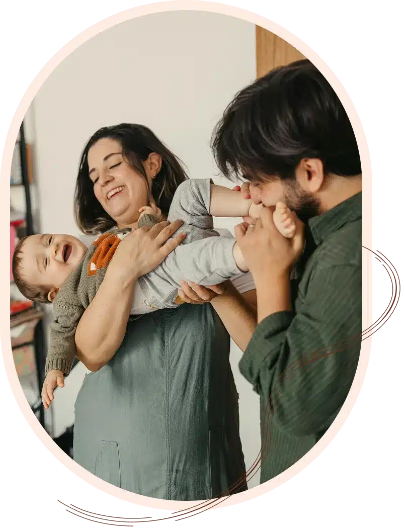 Parents playing and laughing with their baby.