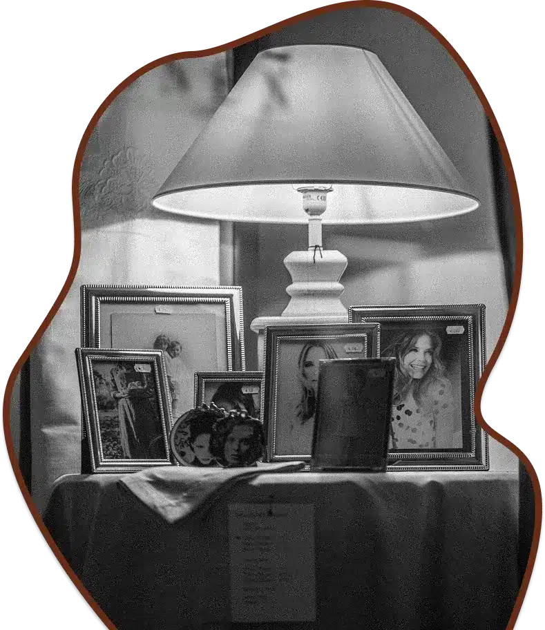 A collection of framed photos and a lamp.