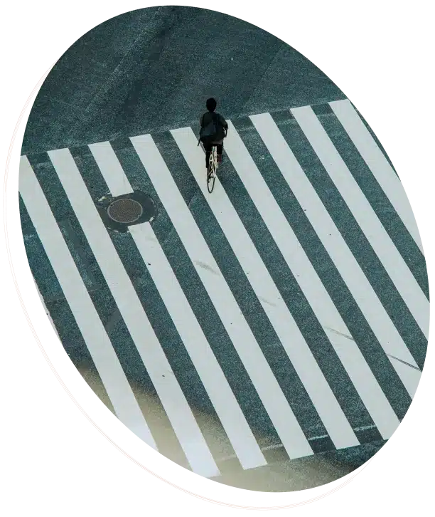 A person on a bicycle rides across a crosswalk.