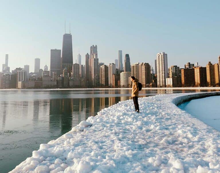 A person views a skyline from a snowy path.