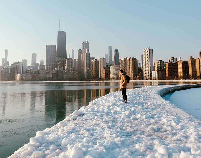 A person views a skyline from a snowy path.