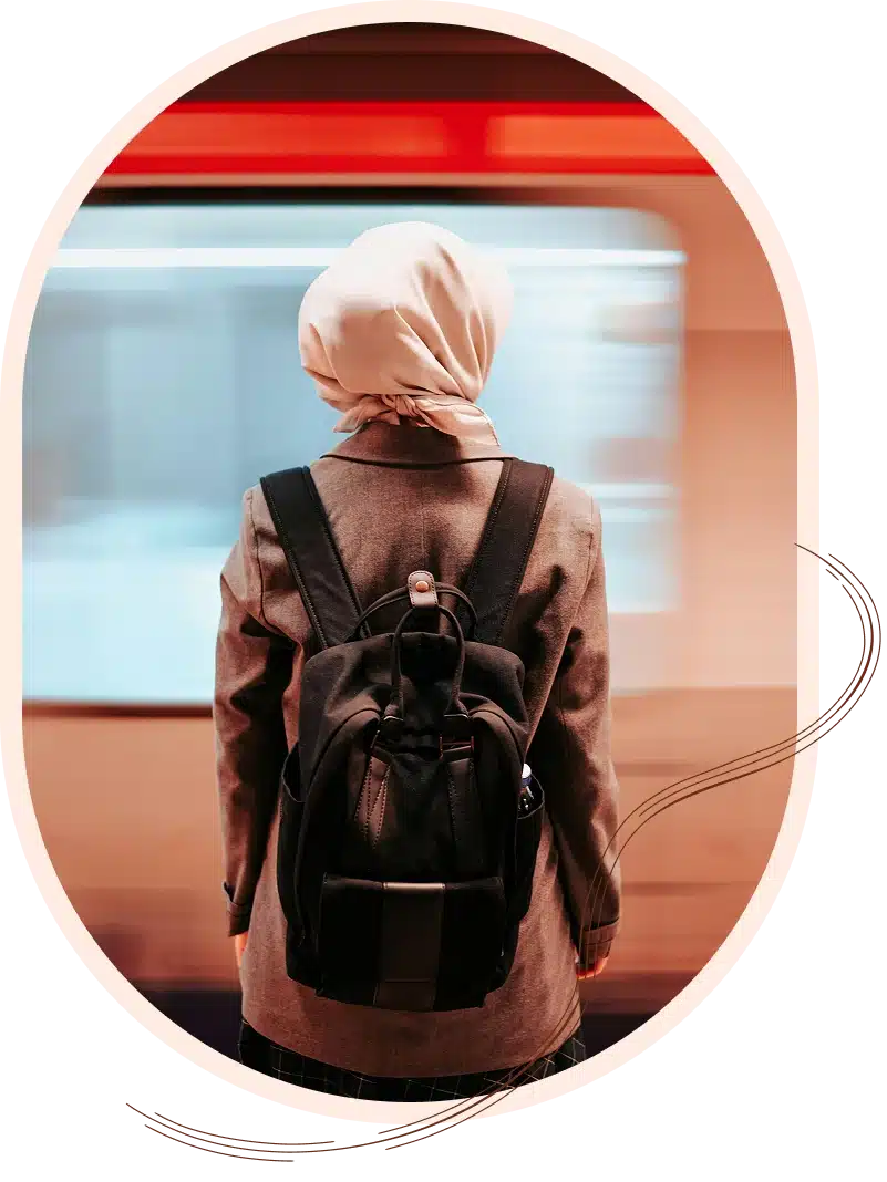 Woman in headscarf on a train platform.