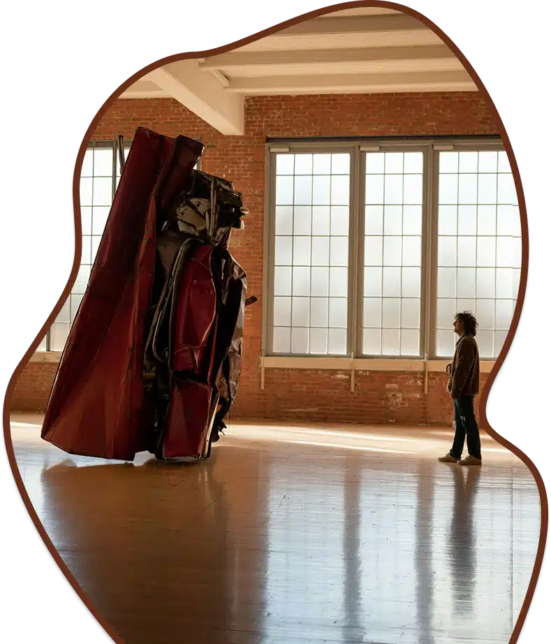 A person views a large, abstract metal sculpture.