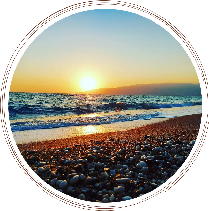 A pebbly beach at sunset.
